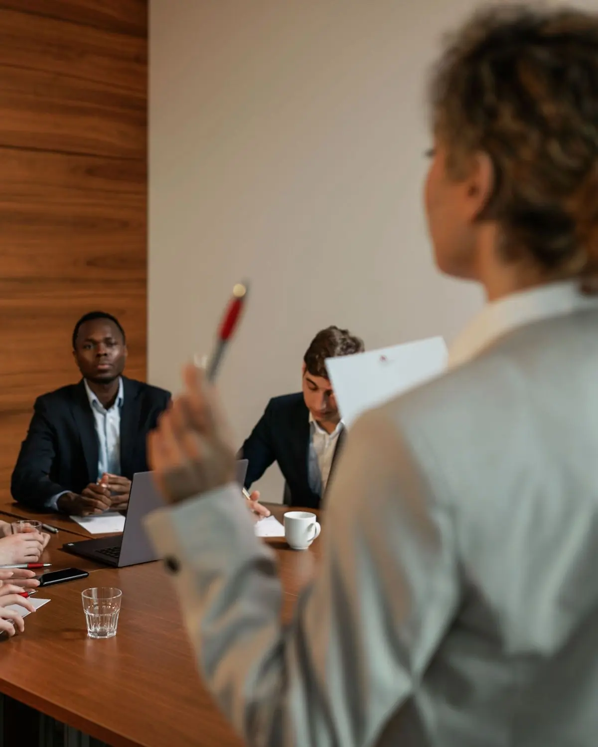Two people at a table during a client briefing, one taking notes.