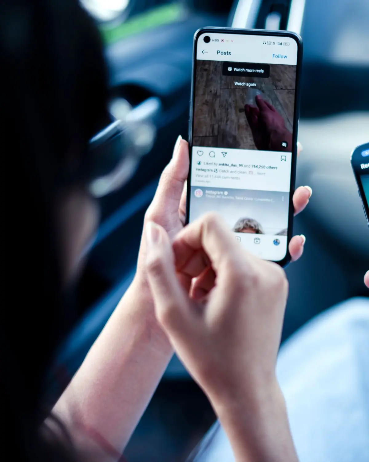 Two people in a car looking at a phone.